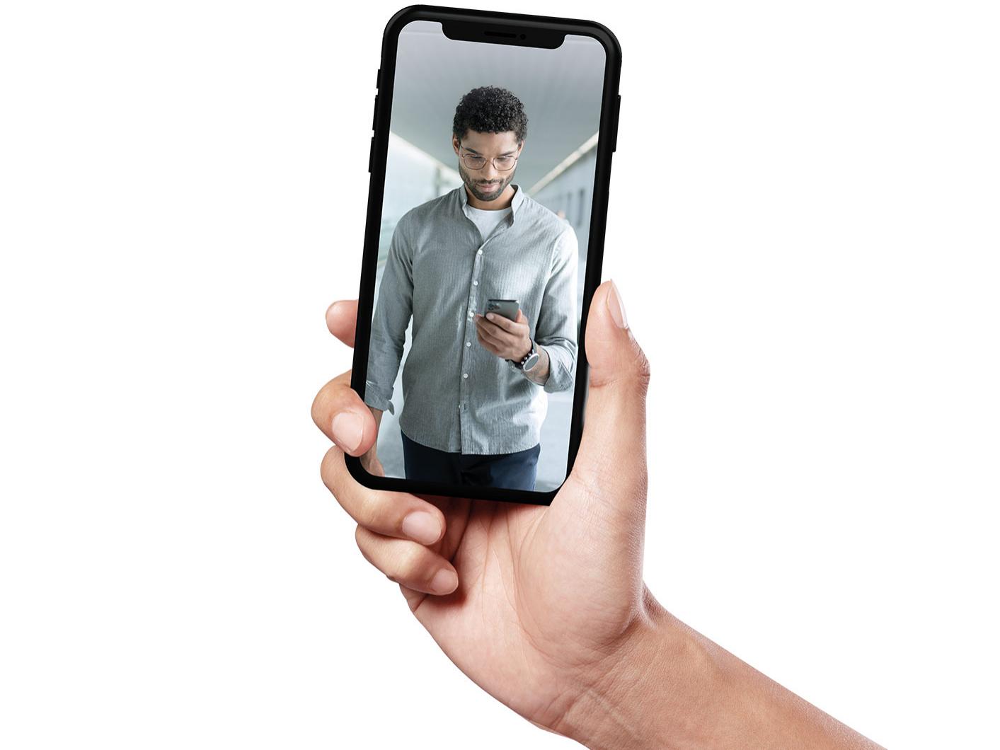 スマートフォンの中に、ZEISS SmartLifeレンズを着けて歩く短髪の若い男性の姿。