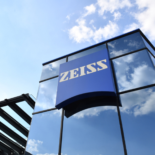 大きなZEISSロゴが付いた、現代的なガラスのビルの画像。 