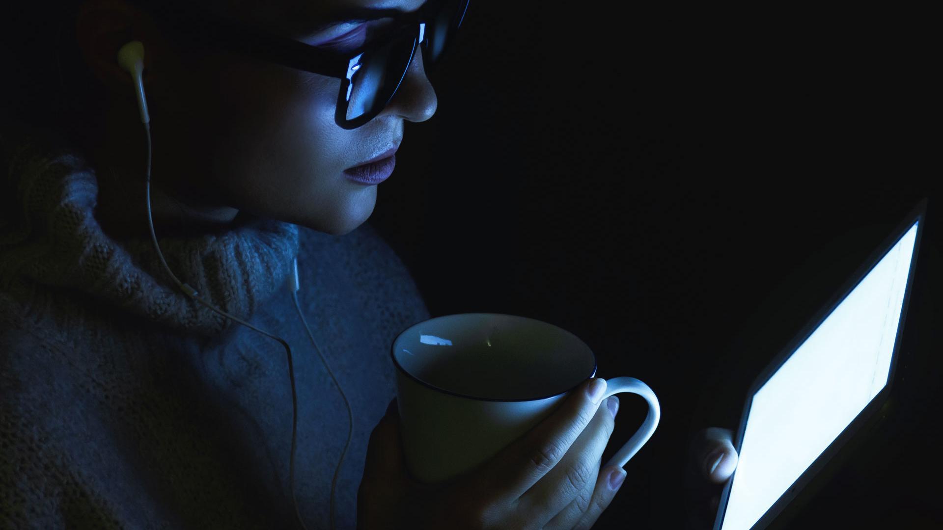 Young woman wearing a warm pullover is using tablet PC