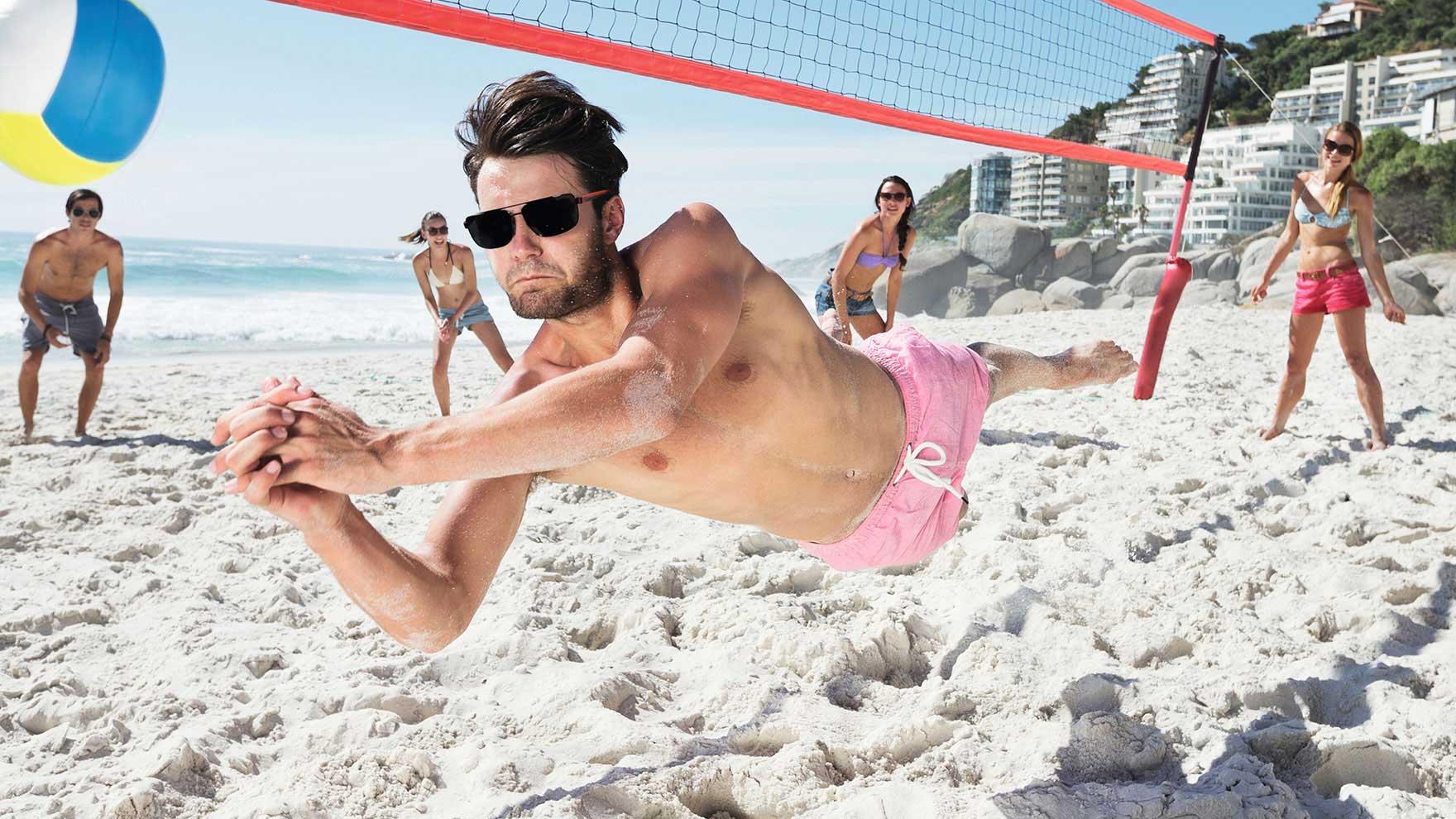 People at the beach playing beach volleyball