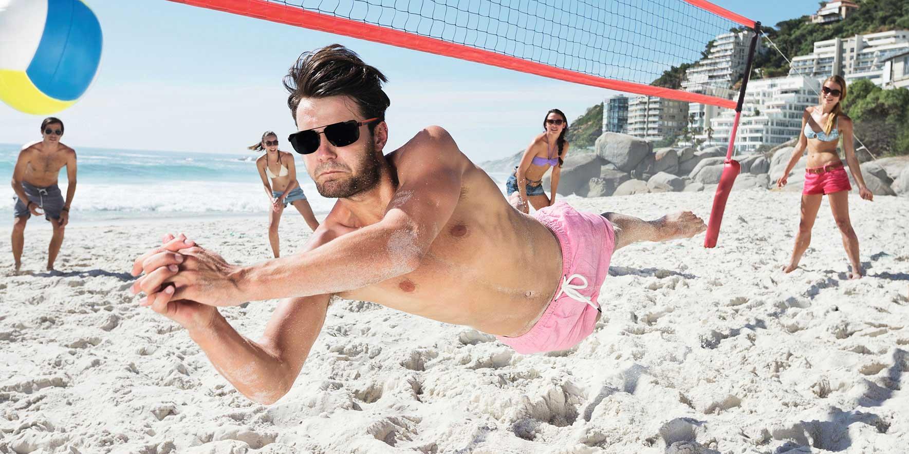 People at the beach playing beach volleyball